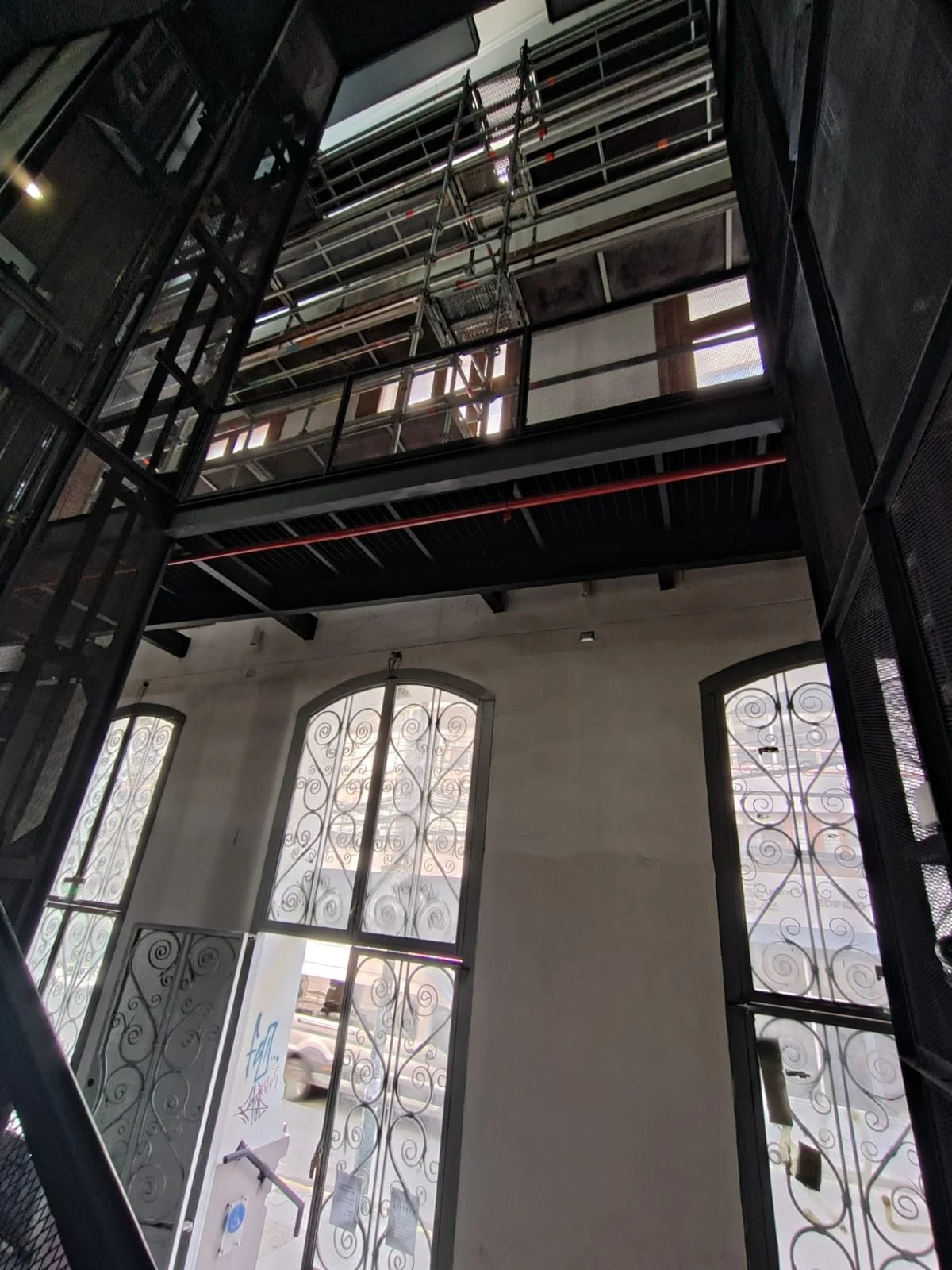 Andamio interior en un edificio patrimonial con ventanales en arco